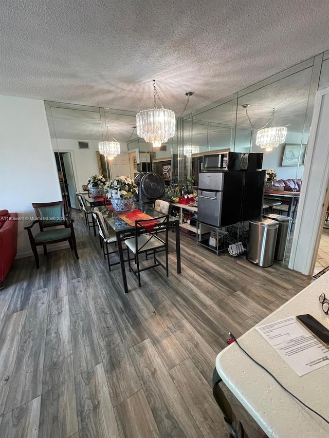 7400 NW 17th St Unit 209, Plantation, FL 33313 - dining room with a chandelier, wood finished floors, and a textured ceiling