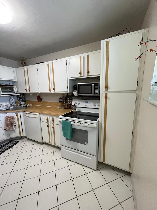 7400 NW 17th St Unit 209, Plantation, FL 33313 - kitchen featuring white appliances, white cabinetry, light tile patterned floors, and light countertops