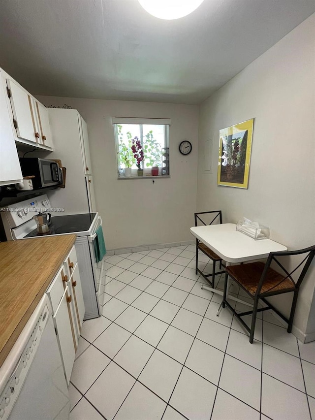 7400 NW 17th St Unit 209, Plantation, FL 33313 - kitchen featuring white appliances, white cabinets, baseboards, and light tile patterned floors