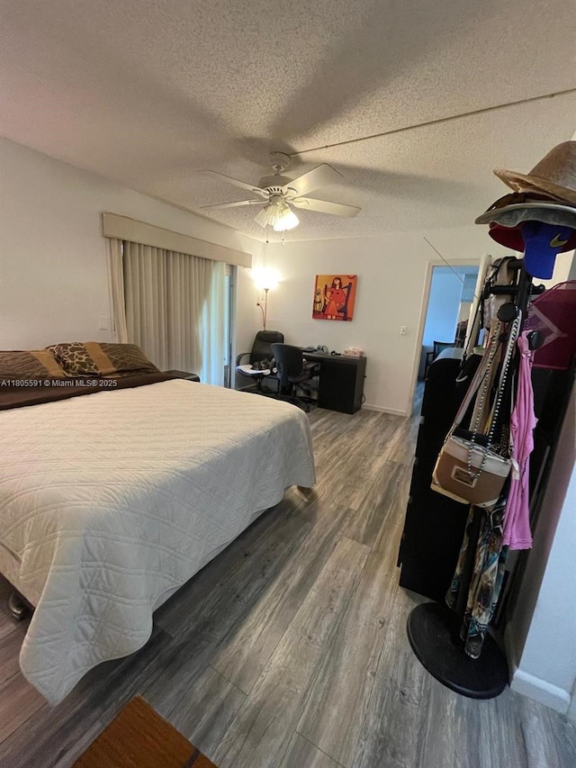 7400 NW 17th St Unit 209, Plantation, FL 33313 - bedroom with wood finished floors, baseboards, a ceiling fan, and a textured ceiling
