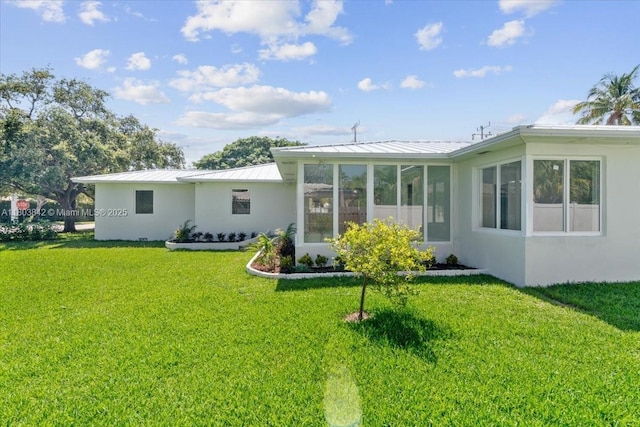 1459 Jefferson St, Hollywood, FL 33020 - back of property with a standing seam roof, a lawn, stucco siding, and metal roof