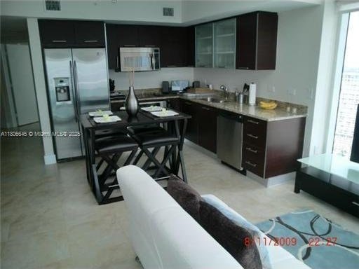 41 SE 5th St Unit 2317, Miami, FL 33131 - kitchen featuring appliances with stainless steel finishes, a sink, glass insert cabinets, and light countertops