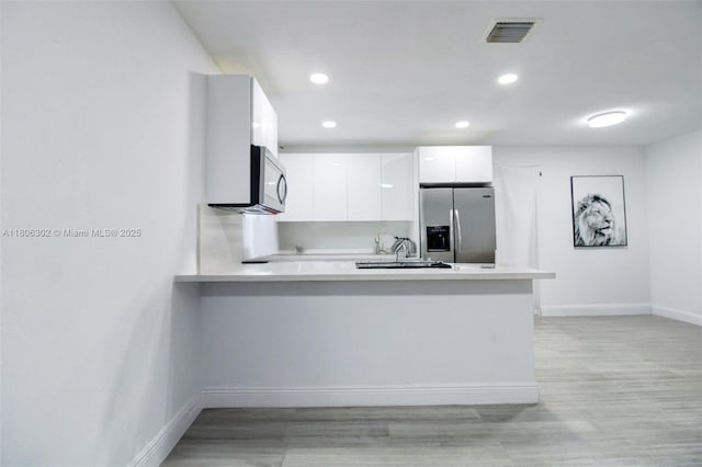 5510 NW 30th Ave, Miami, FL 33142 - kitchen featuring appliances with stainless steel finishes, a peninsula, modern cabinets, baseboards, and light countertops