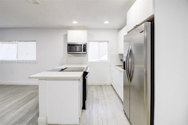 5510 NW 30th Ave, Miami, FL 33142 - kitchen featuring appliances with stainless steel finishes, light wood-style floors, white cabinets, modern cabinets, and baseboards
