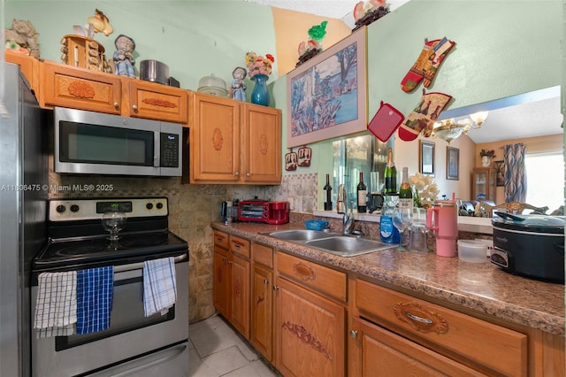 2401 NW 56th Ave Unit 3-202, Lauderhill, FL 33313 - kitchen featuring stainless steel appliances, a sink, light tile patterned flooring, and brown cabinets