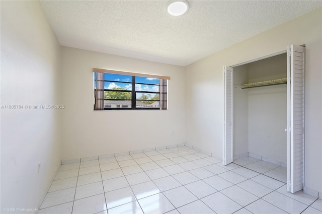 3521 SW 105th Ct, Miami, FL 33165 - unfurnished bedroom with a textured ceiling, a closet, light tile patterned floors, and baseboards