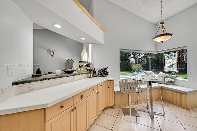 5362 NW 108th Way, Coral Springs, FL 33076 - kitchen with high vaulted ceiling, light tile patterned floors, a textured ceiling, pendant lighting, and breakfast area