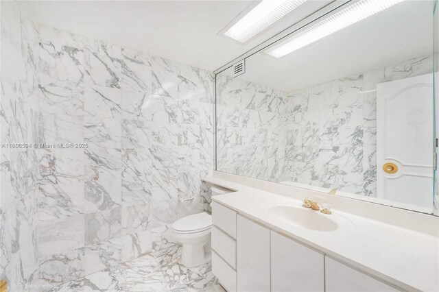 5255 Collins Ave Unit 14D, Miami Beach, FL 33140 - bathroom featuring vanity, toilet, marble finish floors, and tile walls