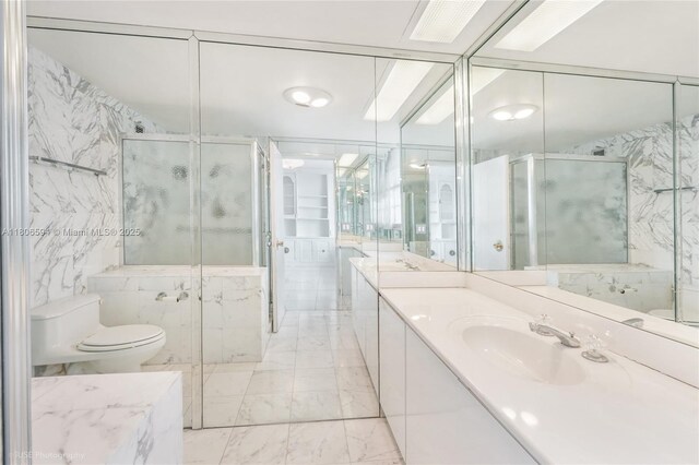 5255 Collins Ave Unit 14D, Miami Beach, FL 33140 - full bath featuring marble finish floors, vanity, a marble finish shower, toilet, and tile walls