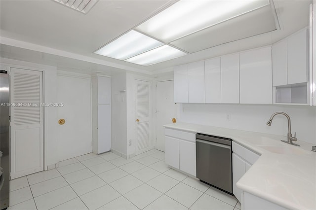 5255 Collins Ave Unit 14D, Miami Beach, FL 33140 - kitchen with stainless steel dishwasher, a sink, white cabinetry, light countertops, and light tile patterned floors