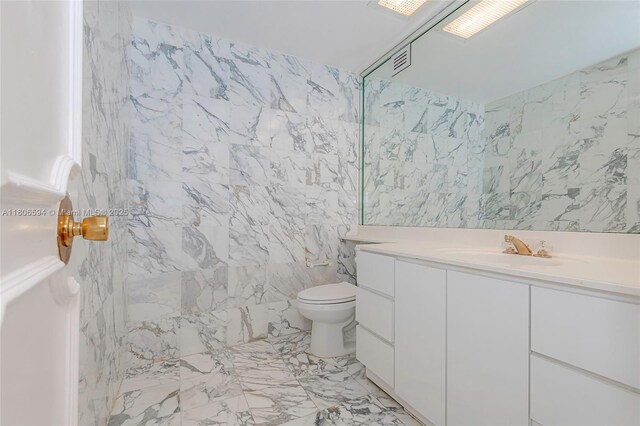 5255 Collins Ave Unit 14D, Miami Beach, FL 33140 - full bath featuring tile walls, marble tiled floors, vanity, and toilet