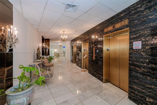 5255 Collins Ave Unit 14D, Miami Beach, FL 33140 - corridor with a chandelier, elevator, wallpapered walls, marble look tiles, and a paneled ceiling
