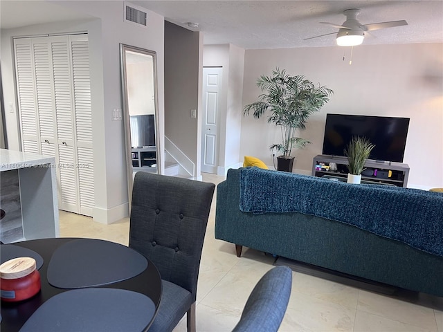 living area featuring ceiling fan and baseboards