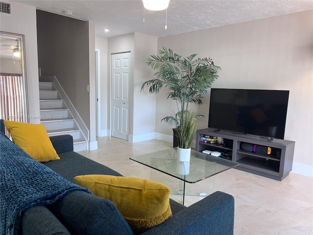 living area featuring stairs, baseboards, recessed lighting, and a textured ceiling