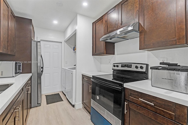 4029 SW 22nd St, West Park, FL 33023 - kitchen featuring appliances with stainless steel finishes, washing machine and dryer, exhaust hood, light wood-style floors, and dark brown cabinets