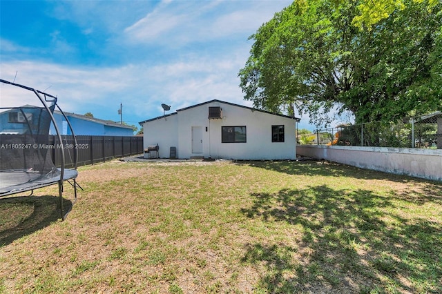 4029 SW 22nd St, West Park, FL 33023 - back of house featuring a trampoline, a fenced backyard, and stucco siding