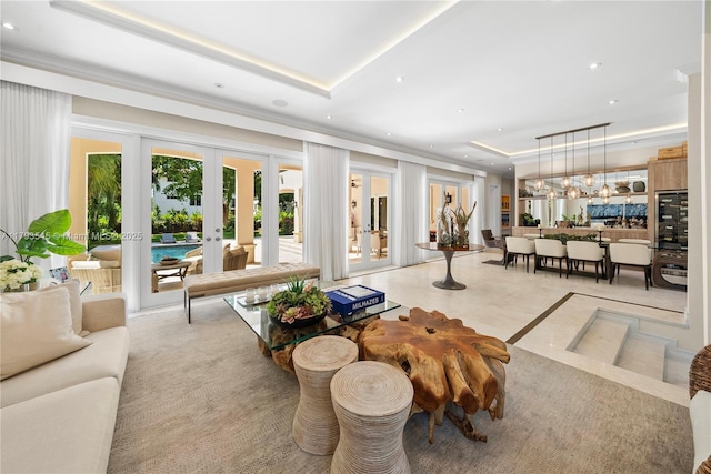 living room featuring a tray ceiling, recessed lighting, french doors, and ornamental molding
