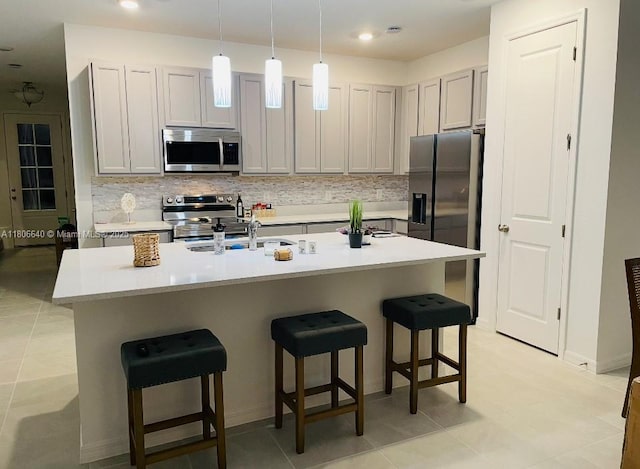 726 Longboat, Davenport, FL 33896 - kitchen featuring stainless steel appliances, a breakfast bar area, tasteful backsplash, light countertops, and pendant lighting
