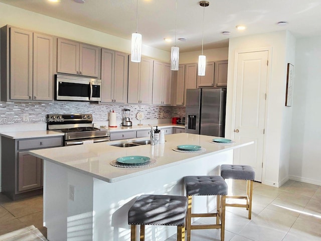 726 Longboat, Davenport, FL 33896 - kitchen featuring appliances with stainless steel finishes, tasteful backsplash, light countertops, a kitchen bar, and a center island with sink