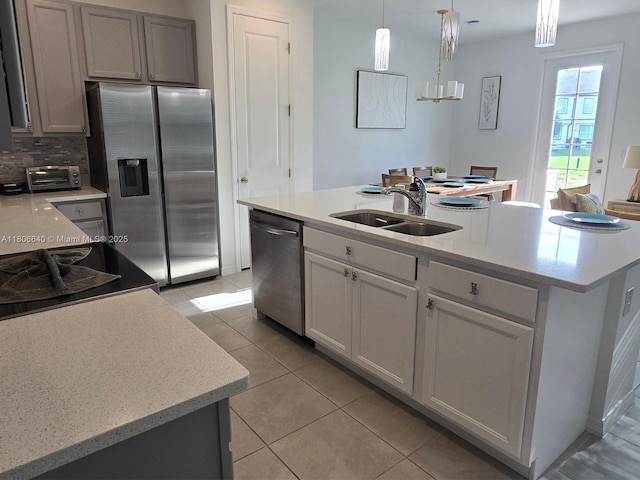 726 Longboat, Davenport, FL 33896 - kitchen with stainless steel appliances, light tile patterned floors, decorative light fixtures, a kitchen island with sink, and decorative backsplash