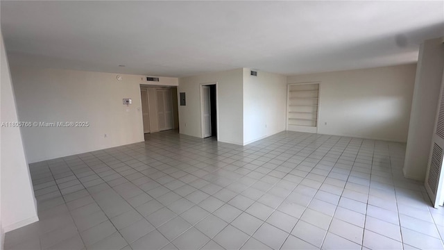 625 Biltmore Way Unit 707, Coral Gables, FL 33134 - unfurnished room with built in shelves, light tile patterned floors, and a heating unit