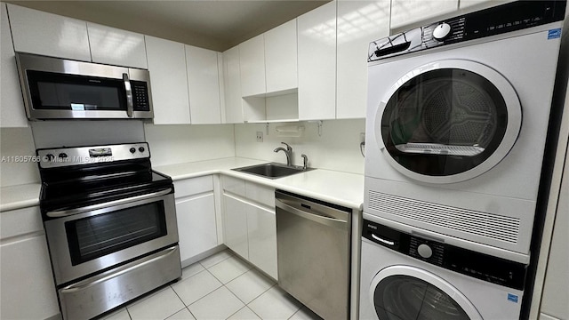 625 Biltmore Way Unit 707, Coral Gables, FL 33134 - kitchen with stacked washing machine and dryer, appliances with stainless steel finishes, light countertops, and white cabinets