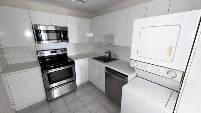 625 Biltmore Way Unit 707, Coral Gables, FL 33134 - kitchen with stainless steel appliances, stacked washer / drying machine, a sink, light countertops, and white cabinets