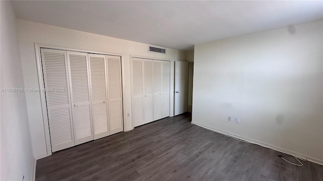 625 Biltmore Way Unit 707, Coral Gables, FL 33134 - unfurnished bedroom featuring dark wood-type flooring, baseboards, and multiple closets