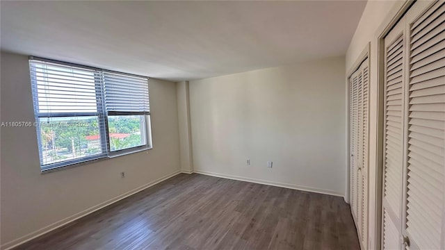 625 Biltmore Way Unit 707, Coral Gables, FL 33134 - unfurnished bedroom featuring dark wood-style floors and baseboards