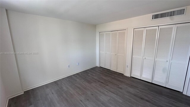 625 Biltmore Way Unit 707, Coral Gables, FL 33134 - unfurnished bedroom featuring multiple closets and dark wood-style floors