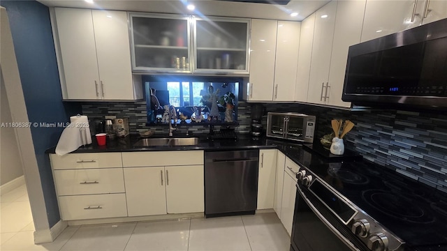 12500 SW 5th Ct Unit 307M, Pembroke Pines, FL 33027 - kitchen featuring black appliances, a sink, white cabinetry, and tasteful backsplash