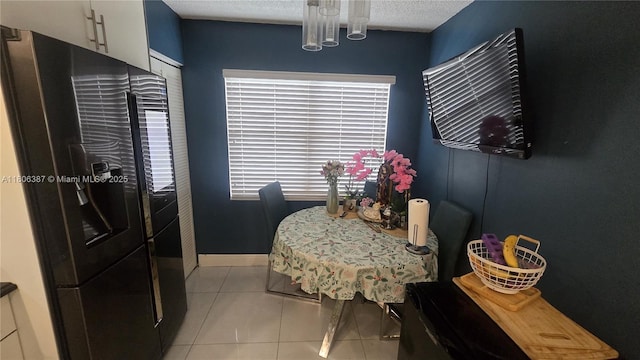 12500 SW 5th Ct Unit 307M, Pembroke Pines, FL 33027 - dining space featuring light tile patterned flooring, a textured ceiling, and baseboards