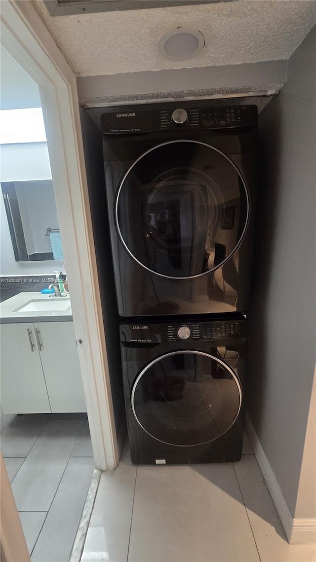 12500 SW 5th Ct Unit 307M, Pembroke Pines, FL 33027 - laundry area with stacked washer and clothes dryer, baseboards, and tile patterned flooring