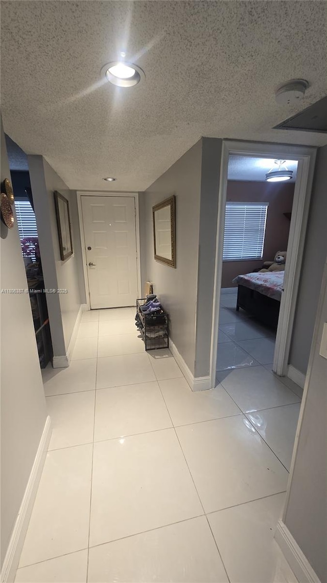 12500 SW 5th Ct Unit 307M, Pembroke Pines, FL 33027 - hallway featuring baseboards, a textured ceiling, and light tile patterned floors