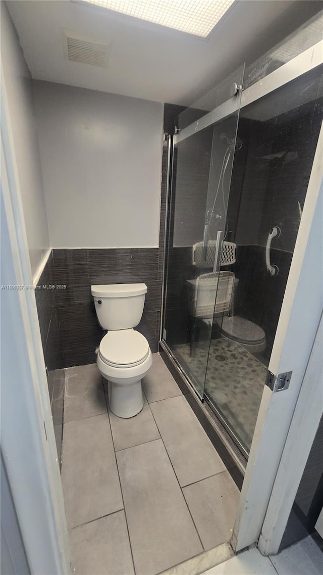 12500 SW 5th Ct Unit 307M, Pembroke Pines, FL 33027 - bathroom featuring toilet, wainscoting, a shower stall, tile walls, and tile patterned flooring