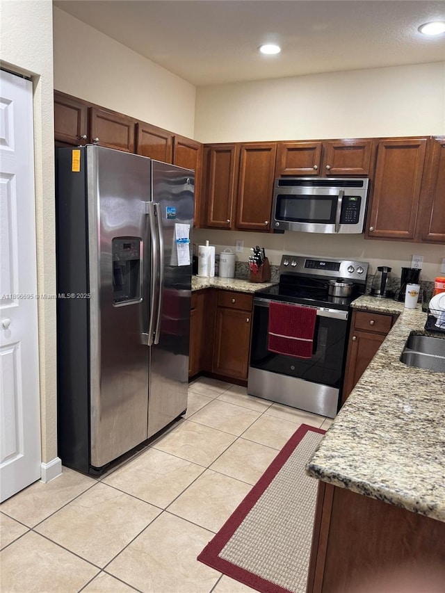 11564 SW 151st Ave, Miami, FL 33196 - kitchen with appliances with stainless steel finishes, light tile patterned floors, light stone countertops, a sink, and recessed lighting