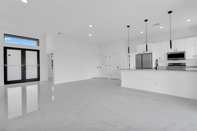 2518 26th St W, Lehigh Acres, FL 33971 - unfurnished living room featuring light marble finish flooring, a sink, recessed lighting, a towering ceiling, and french doors