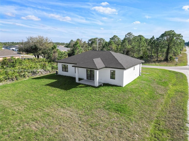 2518 26th St W, Lehigh Acres, FL 33971 - rear view of house with a lawn, roof with shingles, and stucco siding