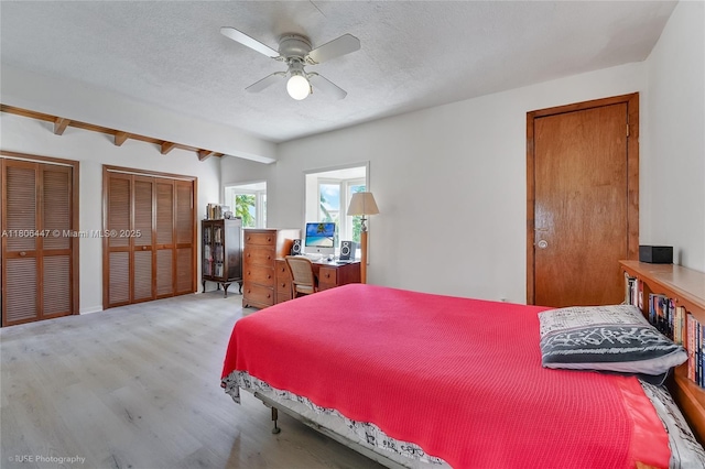 1727 SW 11th Ter, Miami, FL 33135 - bedroom with light wood-style floors, multiple closets, beamed ceiling, a textured ceiling, and a ceiling fan