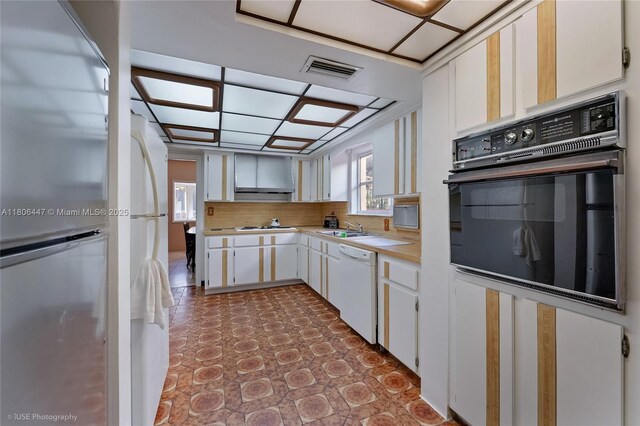 1727 SW 11th Ter, Miami, FL 33135 - kitchen with white appliances, light countertops, a sink, white cabinetry, and wall chimney range hood