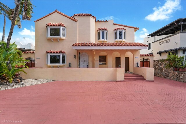 1727 SW 11th Ter, Miami, FL 33135 - mediterranean / spanish-style home with stucco siding, a fenced front yard, and a tile roof