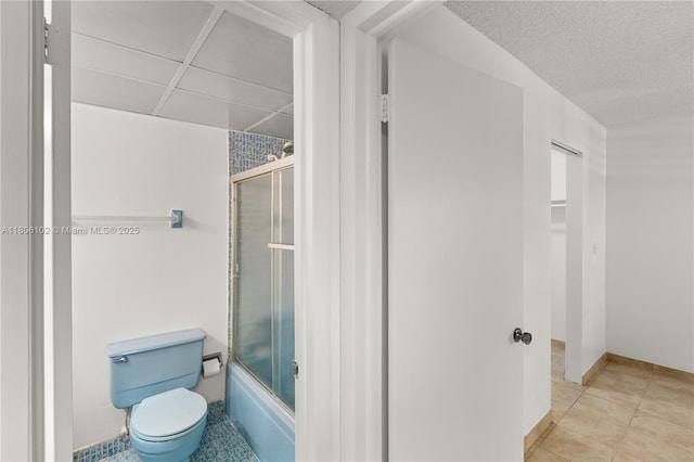 9310 W Flagler St Unit 111A, Miami, FL 33174 - full bathroom featuring toilet, combined bath / shower with glass door, tile patterned flooring, and a textured ceiling