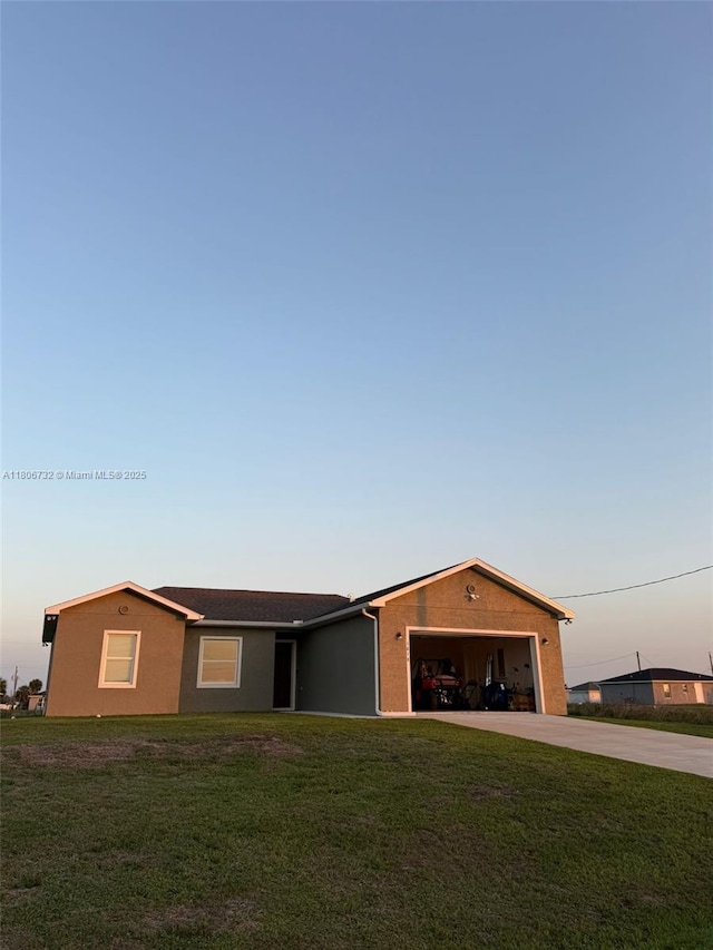 1818 Inwood Rd, La Belle, FL 33935 - single story home with concrete driveway, an attached garage, a yard, and stucco siding