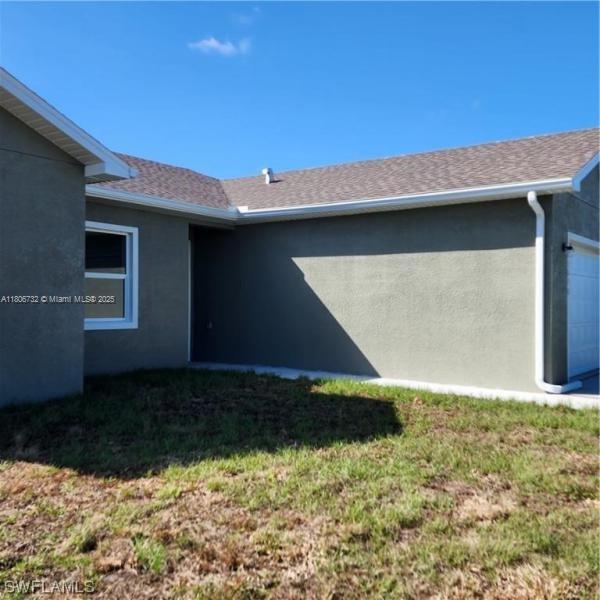 1818 Inwood Rd, La Belle, FL 33935 - property entrance featuring stucco siding, a garage, and a lawn