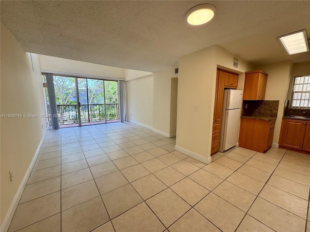 8810 Fontainebleau Blvd Unit 318, Miami, FL 33172 - spare room with a textured ceiling, plenty of natural light, light tile patterned floors, and baseboards