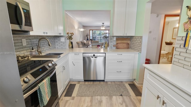 8605 W Sample Rd Unit 202, Coral Springs, FL 33065 - kitchen featuring appliances with stainless steel finishes, a sink, decorative backsplash, and crown molding