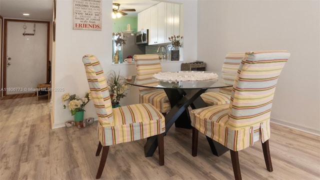 8605 W Sample Rd Unit 202, Coral Springs, FL 33065 - dining space featuring light wood-type flooring, a ceiling fan, and baseboards