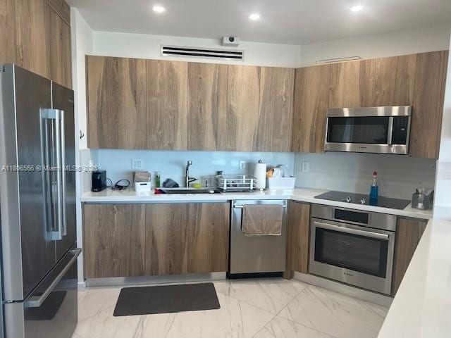 19500 Turnberry Way Unit 12A, Aventura, FL 33180 - kitchen with stainless steel appliances, modern cabinets, brown cabinetry, and recessed lighting