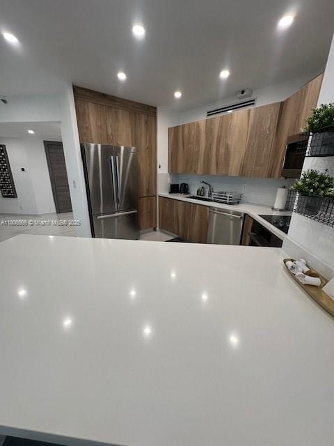 19500 Turnberry Way Unit 12A, Aventura, FL 33180 - kitchen featuring stainless steel appliances, modern cabinets, light countertops, brown cabinets, and recessed lighting