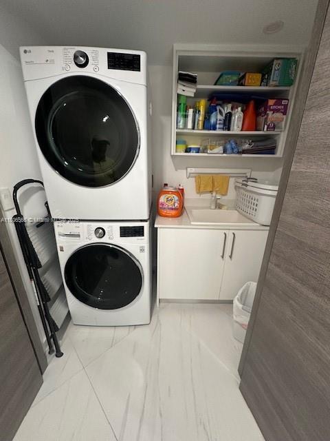 19500 Turnberry Way Unit 12A, Aventura, FL 33180 - washroom with stacked washer and clothes dryer and cabinet space